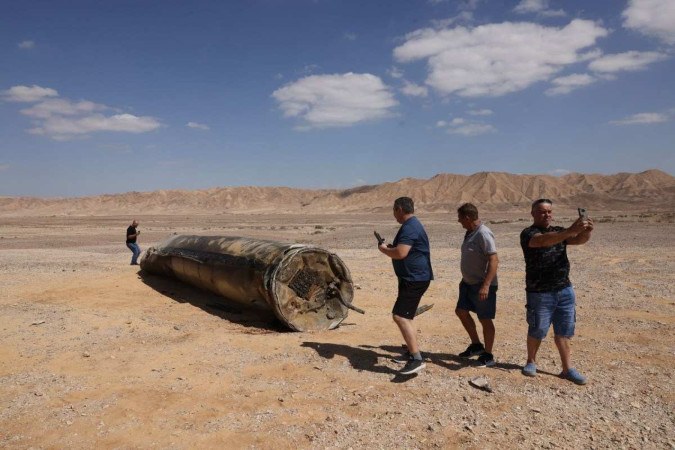 Israelense faz selfie diante de míssil iraniano, no Deserto do Negev, perto da cidade de Arad  -  (crédito: Menahem Kahana/AFP)