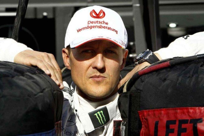 Nesta foto de arquivo tirada em 22 de novembro de 2012, Michael Schumacher se inclina entre dois pneus no autódromo de Interlagos, em São Paulo -  (crédito: ORLANDO KISSNER / AFP)