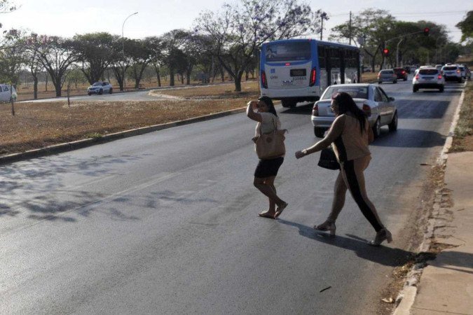 Faixa de pedestres com sinalização apagada na via L2 Sul obriga pessoas a se arriscarem na travessia. Motoristas ficam sem referência