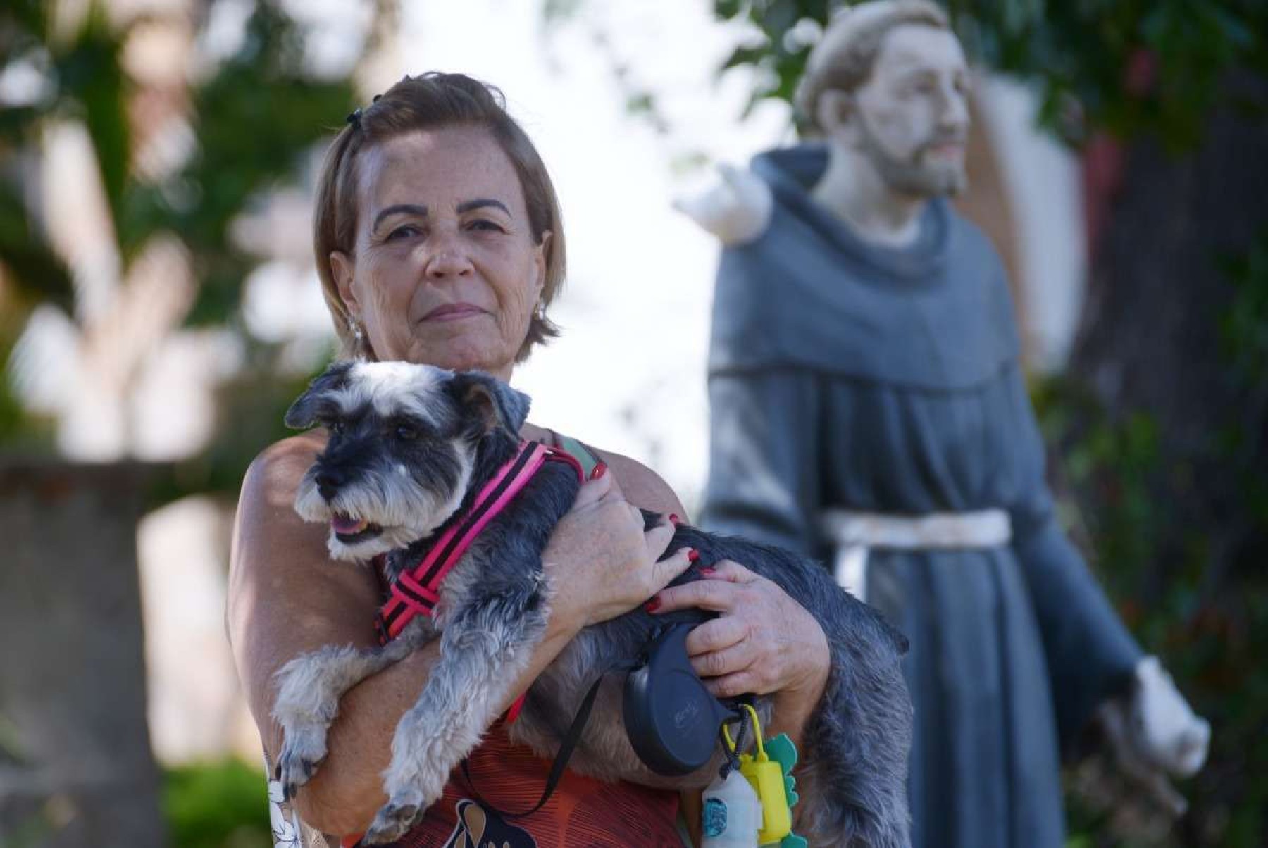 A schnauzer Duda é levada pela tutora Christiane Maroto para receber a benção dos freires todos os anos, na área externa da basílica 