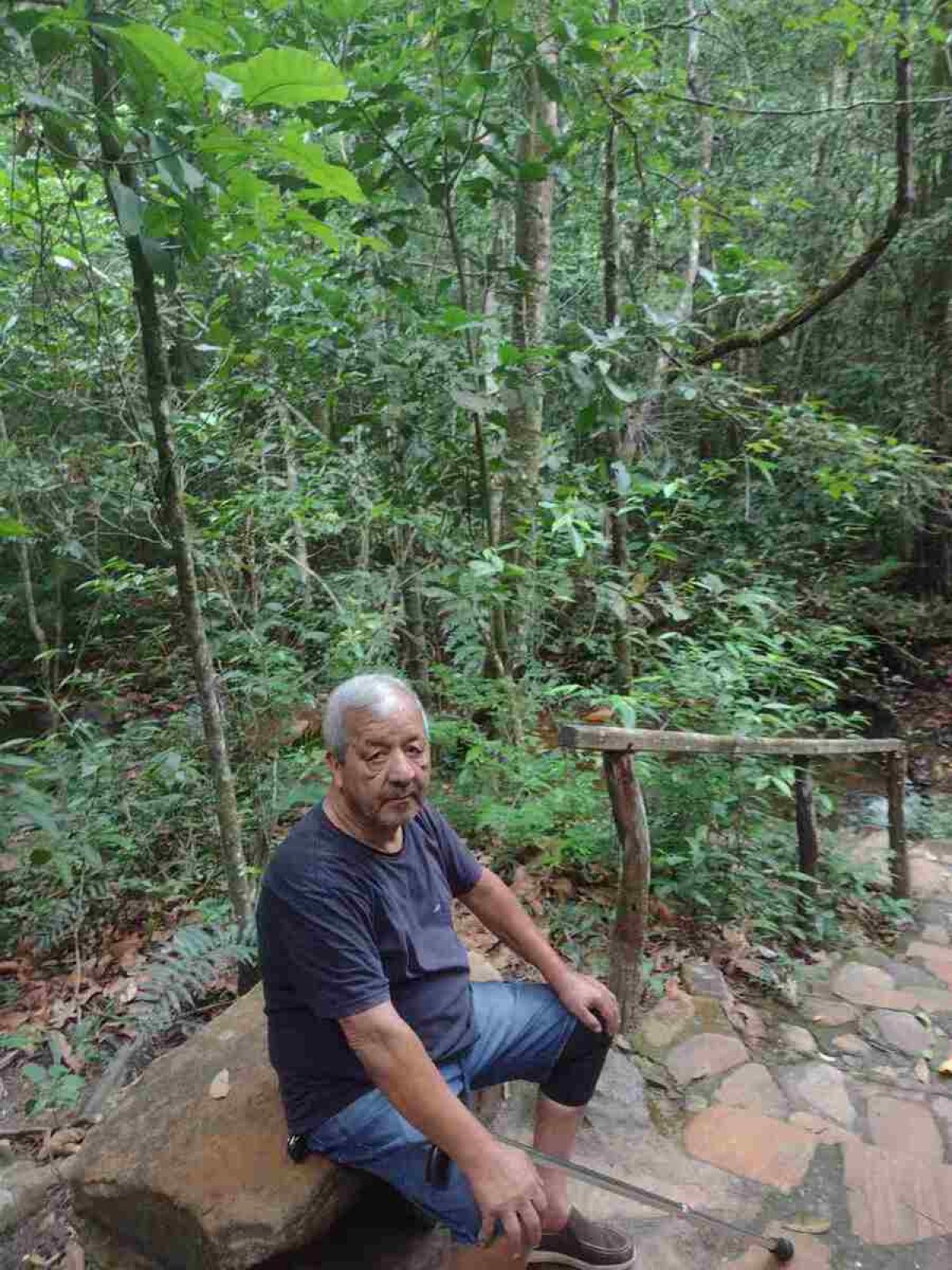 O idoso tem cabelos grisalhos e se locomove com a ajuda de uma bengala