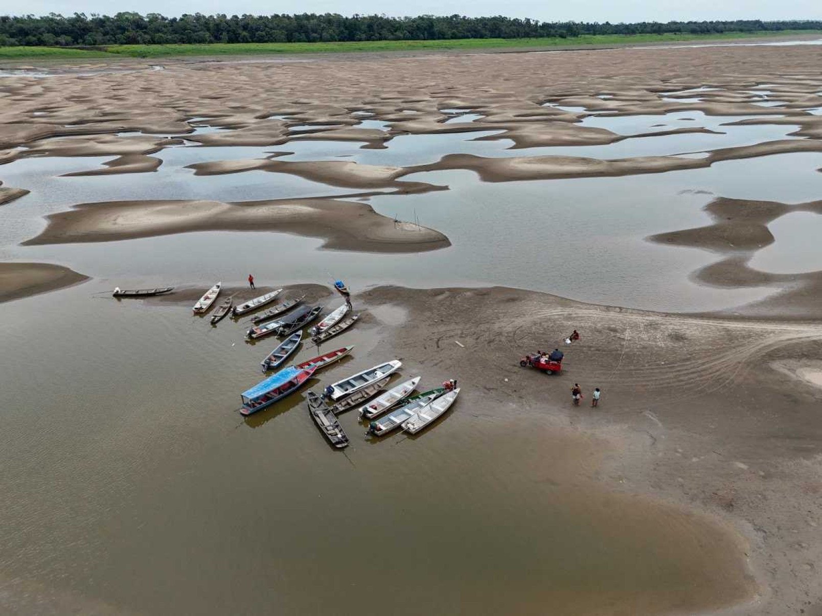  Aerial view of river dwellers using a tricycle to transport food and passengers along the dry bed of the Solimoes River, near the Monte Sinai Community, in Manacapuru, Amazonas state, northern Brazil, on September 30, 2024. Several tributaries of the Amazon River, one of the longest and most abundant in the world, are in a 