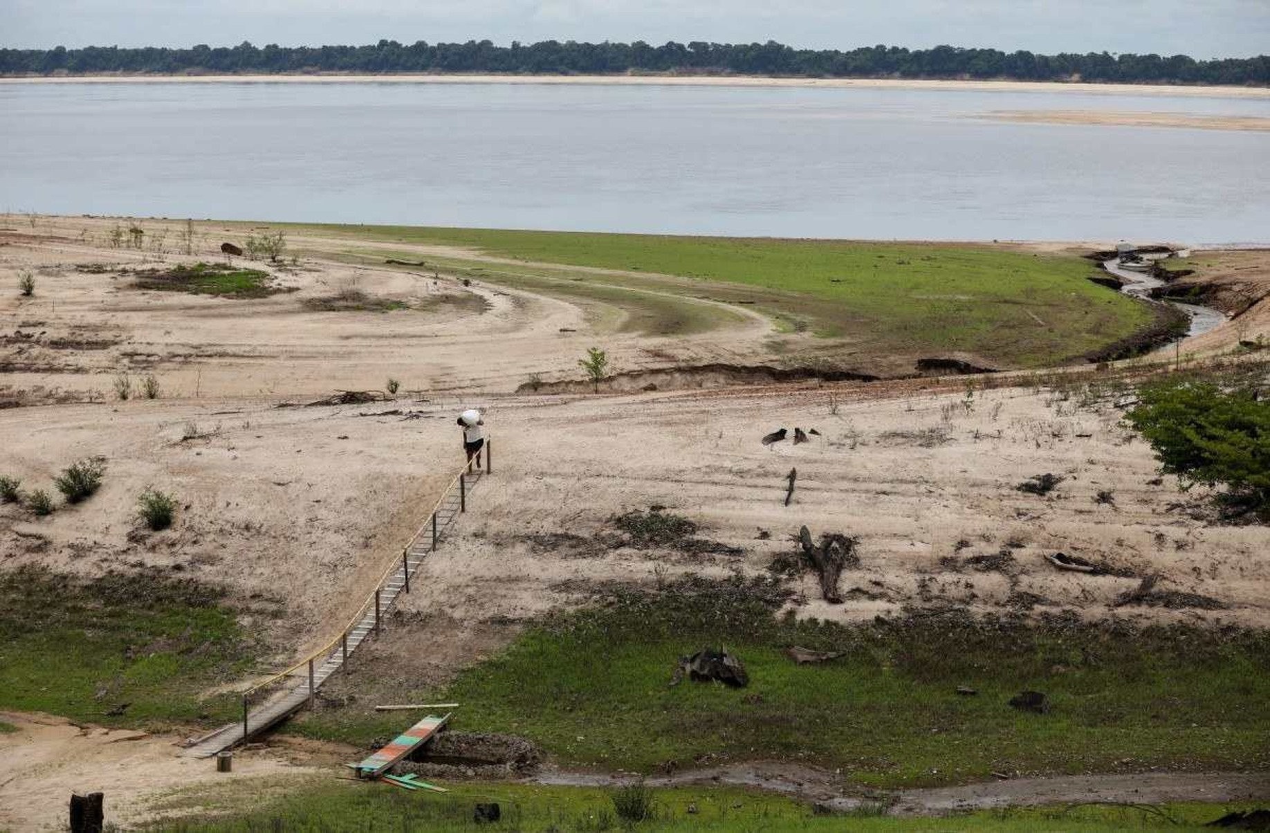  A river dweller carries supplies to Santo Antonio Community affected by drought in Novo Airao, Amazonas state, northern Brazil, on October 1, 2024. Several tributaries of the Amazon River, one of the longest and most abundant in the world, are in a 