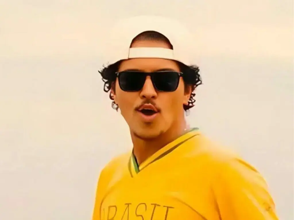 Bruno Mars celebra aniversário no Brasil com camisa do país e bolo inspirado em meme