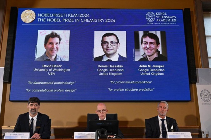 No telão estão os premiados com o Nobel de Química: David Baker, Demis Hassabis e John M. Jumper -  (crédito:  JONATHAN NACKSTRAND / AFP)