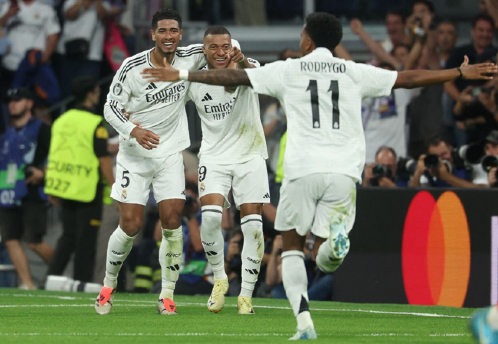  Real Madrid's French forward #09 Kylian Mbappe celebrates with Real Madrid's English midfielder #05 Jude Bellingham and Real Madrid's Brazilian forward #11 Rodrygo after scoring his team's first goal during the UEFA Champions League 1st round day 1 football match between Real Madrid CF and Stuttgart VFB at the Santiago Bernabeu stadium in Madrid on September 17, 2024. (Photo by Pierre-Philippe MARCOU / AFP)
     -  (crédito:  AFP)