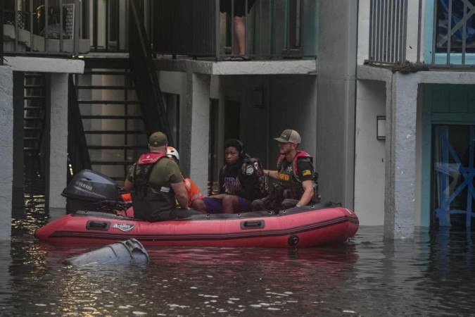 Moradores são resgatados de seu complexo de apartamentos de segundo andar em Clearwater, que foi inundado e transbordando de um riacho devido ao furacão Milton em 10 de outubro de 2024 na Flórida - (crédito: BRYAN R. SMITH / AFP) Moradores são resgatados de seu complexo de apartamentos de segundo andar em Clearwater, que foi inundado e transbordando de um riacho devido ao furacão Milton em 10 de outubro de 2024 na Flórida - (crédito: BRYAN R. SMITH / AFP)
