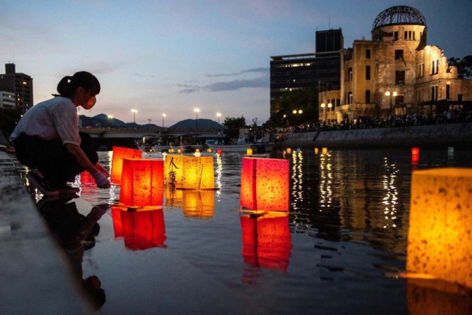 Japoneses lançam lanternas de papel no rio Motoyasu, em frente ao prédio do Salão de Promoção Industrial da Prefeitura de Hiroshima, preservado desde a época da explosão