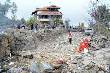 Paramédicos da Cruz Vermelha Libanesa retiram corpo de escombros após ataque israelense ao vilarejo de Aito, no norte do Líbano  -  (crédito: Faith Al-Masri/AFP)