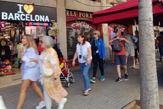 Manifestantes seguram faixa com dizeres 'Diminuição do turismo já' em protesto em julho  -  (crédito: Getty Images)