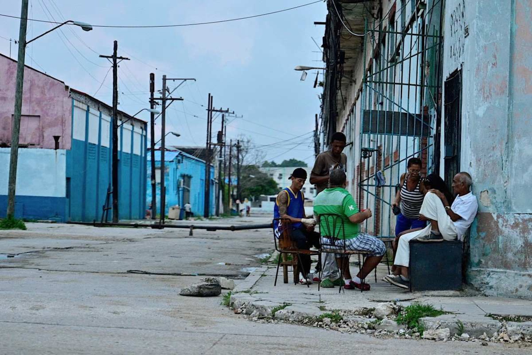     Pessoas permanecem do lado de fora de uma casa durante um apagão nacional causado por uma falha na rede em Havana, em 19 de outubro de 2024. Avarias técnicas, escassez de combustível e alta demanda fizeram com que as usinas termelétricas do país falhassem constantemente, forçando o governo a declarar emergência energética e tomar medidas como fechar escolas e fábricas. (Foto de ADALBERTO ROQUE/AFP)       