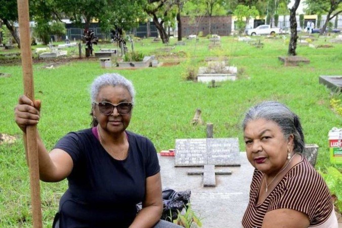 Antônia  Souza e Maria Souza (vassoura) tiraram o mato alto e levaram velas ao túmulo dos pais