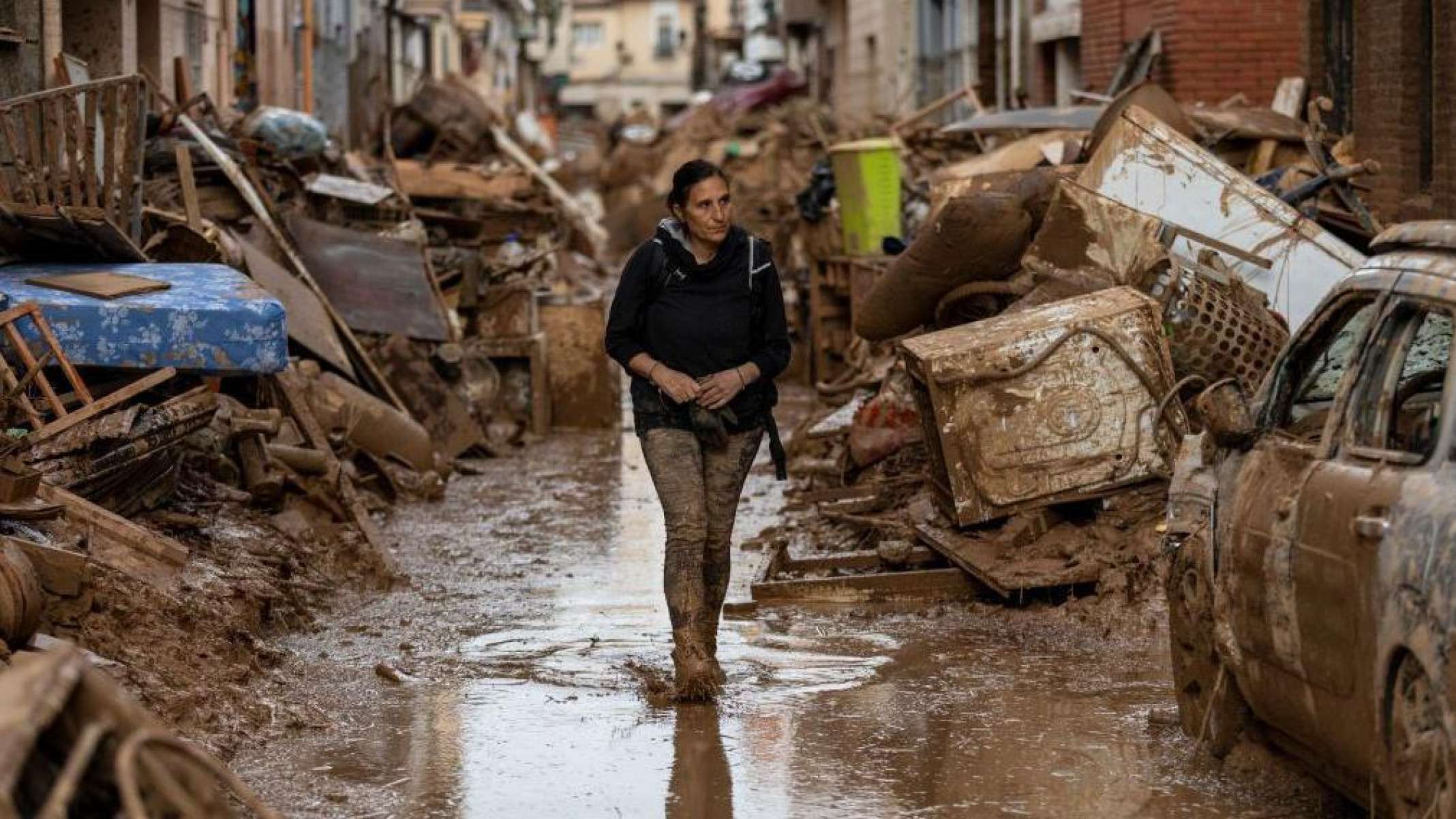 Uma rua em Valência em maio de 2024, e a mesma rua em novembro de 2024 coberta por carros destruídos amontoados  -  (crédito: BBC)