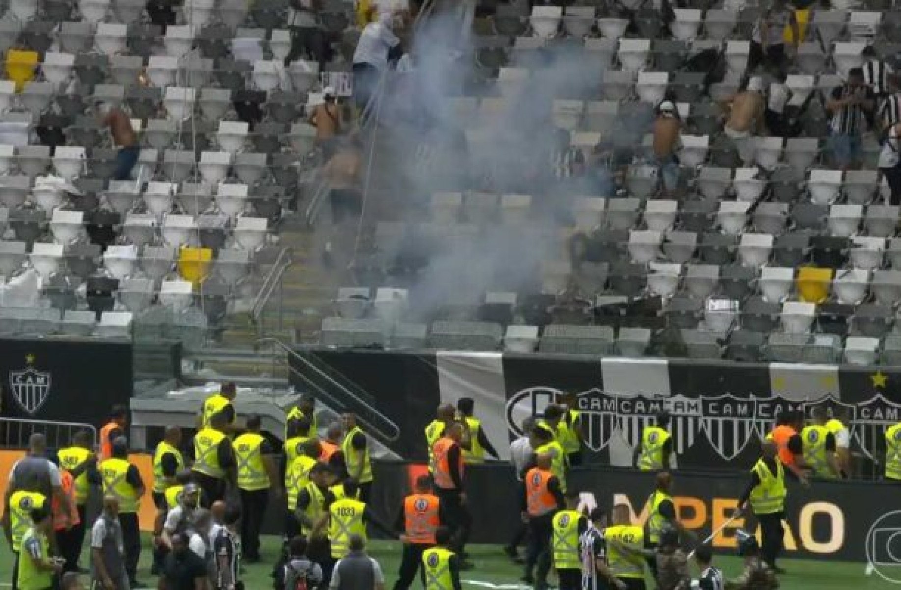 Inconformados com derrota para o Flamengo na final, atleticanos derrubam grades e trocam socos e pontapés com estes profissionais do clube -  (crédito: Reprodução/TV Globo)