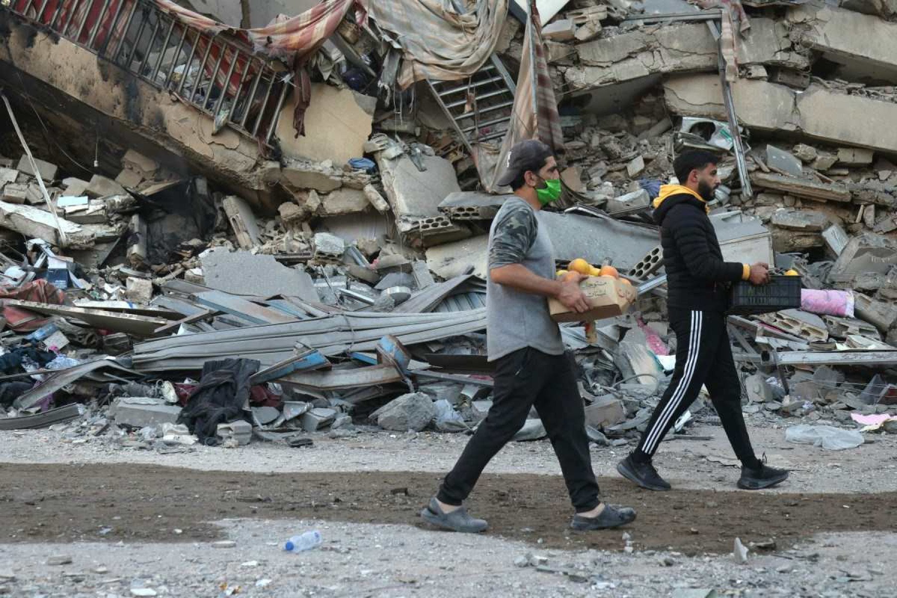 Moradores passam pelo local de um ataque aéreo noturno israelense no bairro de Ghobeiry, no sul de Beirute       