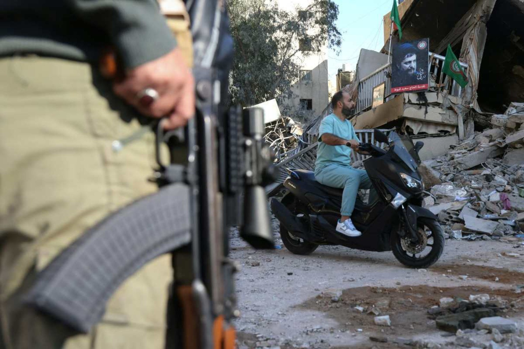 Um homem dirige sua motocicleta passando pelo local de um ataque aéreo noturno israelense no bairro de Ghobeiry, no sul de Beirute.