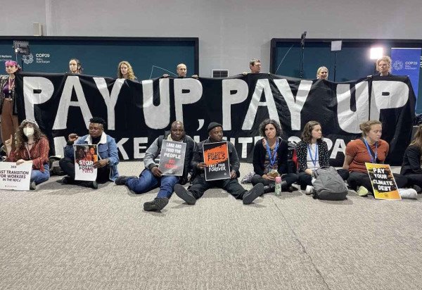 Em protesto silencioso, no local da COP29, ativistas exigem que as nações ricas forneçam financiamento climático aos países em desenvolvimento: US$ 1 trilhão anuais é o valor calculado -  (crédito:  AFP)