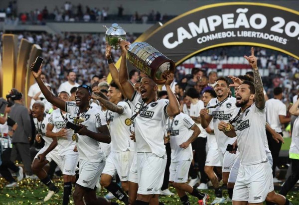  Botafogo's players celebrate with the trophy after winning the Copa Libertadores final football match between Brazilian teams Atletico Mineiro and Botafogo at the Mas Monumental Stadium in Buenos Aires on November 30, 2024. (Photo by ALEJANDRO PAGNI / AFP)
       -  (crédito:  AFP)