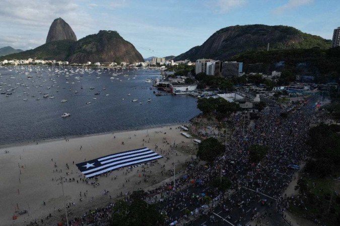  Fans of Botafogo gather at Botafogo beach to wait for their team to celebrate, after winning the 2024 Copa Libertadores, in Rio de Janeiro on December 1, 2024. (Photo by Mauro PIMENTEL / AFP)
       -  (crédito:  AFP)