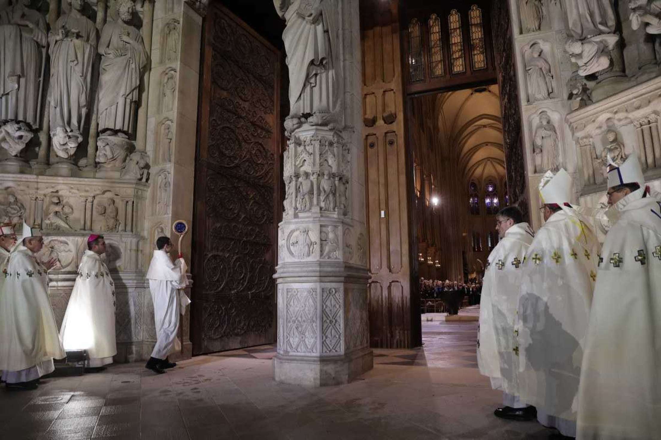 Bispos abrem as portas da Catedral de Notre-Dame durante uma cerimônia para marcar a reabertura da catedral histórica, no centro de Paris, em 7 de dezembro de 2024. Cerca de 50 chefes de estado e de governo são esperados na capital francesa para comparecer à cerimônia que marca a reconstrução da obra-prima gótica cinco anos após o incêndio de 2019 que devastou o marco do patrimônio mundial e derrubou sua torre. Cerca de 250 empresas e centenas de especialistas fizeram parte do projeto de restauração de cinco anos a um custo de centenas de milhões de euros. (Foto de Christophe PETIT TESSON / POOL / AFP)      