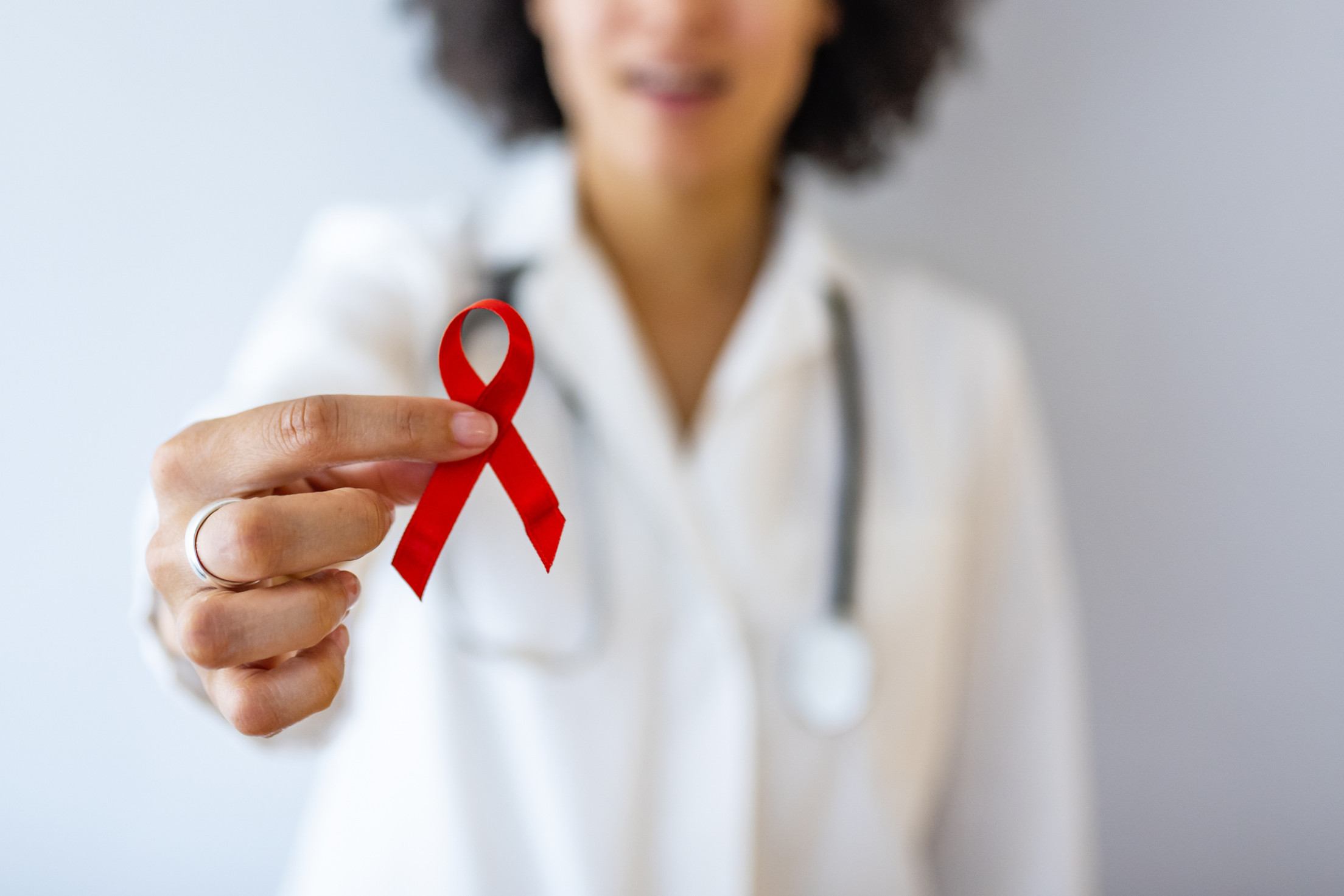  AID, HIV red ribbon. Symbol of awareness, charity, support in disease, illness. Medical health care, help and hope. Sign of healthcare medicine campaign holding in female doctor.
     -  (crédito:  Getty Images)