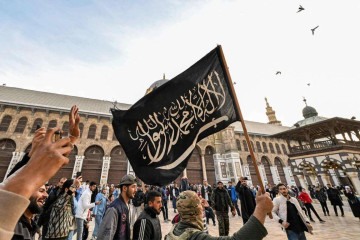  Manifestante segura a bandeira da Shahada islâmica, juramento da fé muçulmana, enquanto caminha no pátio da Mesquita dos Omíadas -  (crédito:  AFP)