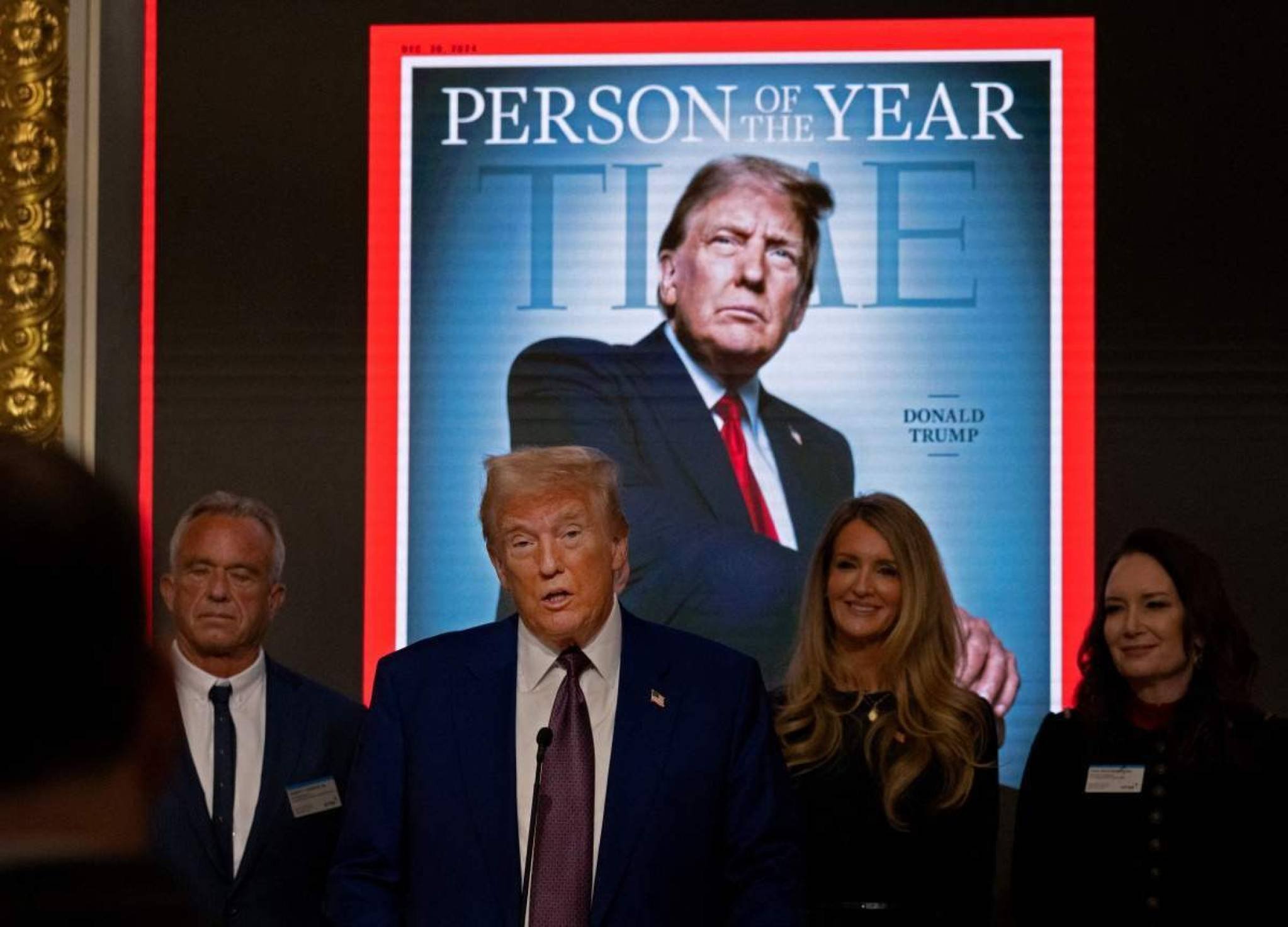 Donald Trump discursa na Bolsa de Valores de Nova York, diante da foto da capa da revista Time Donald Trump discursa na Bolsa de Valores de Nova York, diante da foto da capa da revista Time