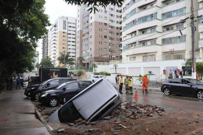  19/12/2024. Crédito: Minervino Júnior/CB/D.A Press. Brasil.  Brasilia - DF. Estragos da chuva em Àguas Claras na avenida do parque. Carro(Fiat Uno) afundou no estacionamento.