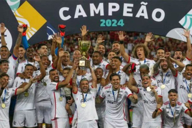 Na sequência, o Flamengo venceu o Nova Iguaçu por 1 a 0 e faturou o título do Carioca de forma hegemônica. Com o título, o clube soma 38 contra 33 do Fluminense, 24 do Vasco e 21 do Botafogo. Foi ainda a sétima vez que o clube ergueu o troféu de forma invicta, com 11 vitórias e quatro empates na campanha de 2024. O time sofreu apenas um gol em toda a competição. Tudo parecia correr bem. Foto: Divulgação/Flamengo 