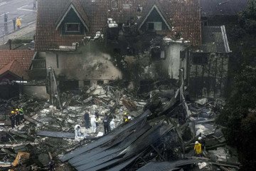  Firefighters and other rescue teams work in the site of a plane crash at the city of Gramado, Rio Grande do Sul state, Brazil, on December 22, 2024. At least nine people died after a small plane crashed in a commercial area of the tourist city of Gramado, in the Brazilian state of Rio Grande do Sul (south), according to authorities. (Photo by MATEUS BRUXEL / AGENCIA RBS / AF / AFP)
       -  (crédito:  AFP)