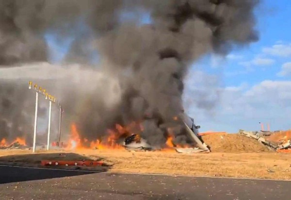  The burning wreckage of a Jeju Air Boeing 737-800 series aircraft is seen after it crashed and burst into flames at Muan International Airport in South Jeolla Province, some 288 kilometres southwest of Seoul on December 29, 2024. A Jeju Air plane O avião com 175 passageiros e seis tripulantes pegou fogo no aeroporto na cidade de Muan, Coreia do Sul, após sair da pista e colidir com uma cerca. Até o momento, 47 mortes foram confirmadas, todas as vítimas estavam na parte de trás da aeronave. (Photo by YONHAP / AFP) / - South Korea OUT / NO ARCHIVES -  RESTRICTED TO SUBSCRIPTION USE
       -  (crédito: YONHAP / AFP)