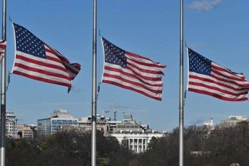 Bandeiras dos EUA baixadas a meio-mastro no National Mall, próximo à Casa Branca (ao fundo), em homenagem a Carter  -  (crédito: Roberto Schmidt/AFP)