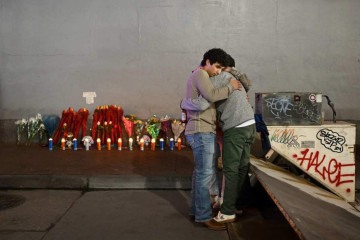 Amigos se abraçam diante de memorial instalado na Bourbon Street, em tributo às vítimas do atentado de 1º de janeiro -  (crédito: Andrew Caballero-Reynolds/AFP)