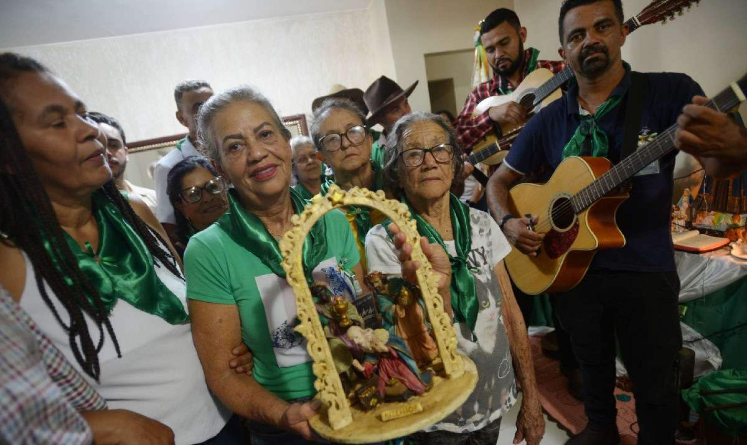 Cecília Rabelo, com imagem do nascimento de Jesus nas mãos, recebe fiéis na casa dela