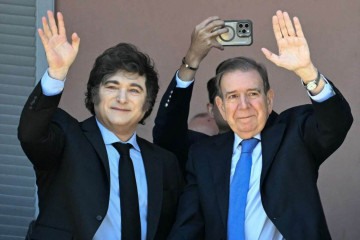 Milei e González (D) acenam para a multidão na Plaza de Mayo, a partir da varanda da Casa Rosada  -  (crédito: Luis Robayo/AFP)