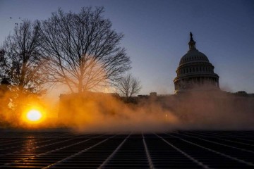 Vapor sobe de duto de ventilação no terreno do edifício do Capitólio dos EUA enquanto o sol se põe em Washington: prédio teve segurança reforçada com cercas  -  (crédito: Roberto Schmidt/AFP)