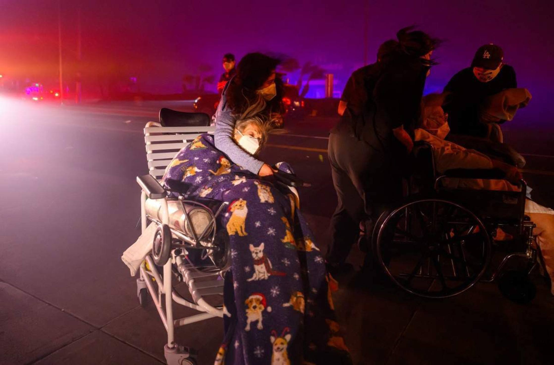 Idosos são rapidamente colocados em ambulâncias, enquanto fogo de aproxima de Pasadena