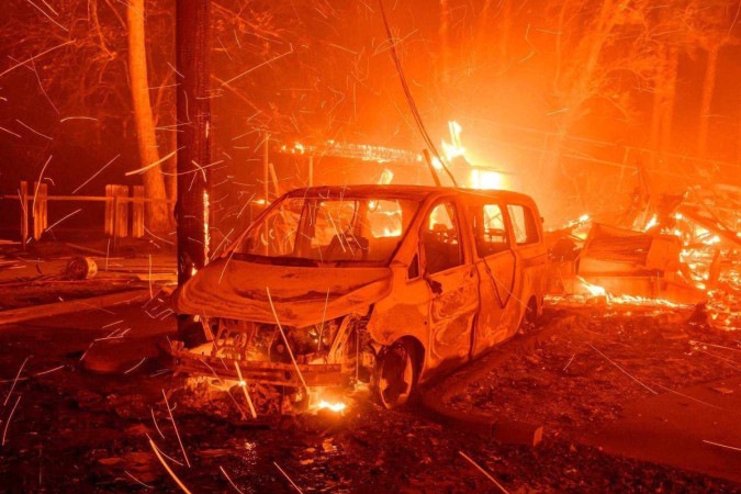 Brasas voam enquanto veículos e propriedades são queimados durante o incêndio em Eaton em Pasadena, Califórnia, em 8 de janeiro de 2025 -  (crédito: JOSH EDELSON / AFP)