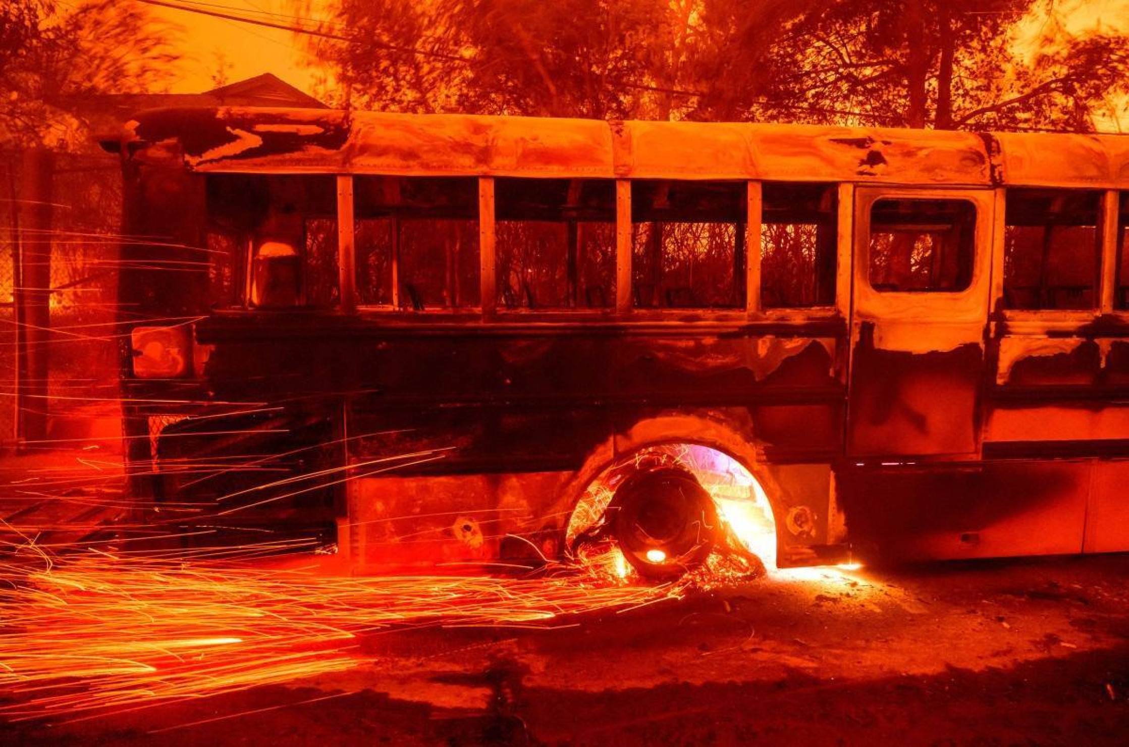 Brasas voam de um ônibus em chamas na escola primária Aveson School of Leaders durante o incêndio em Eaton na área de Altadena, no condado de Los Angeles, Califórnia, em 8 de janeiro de 2025    