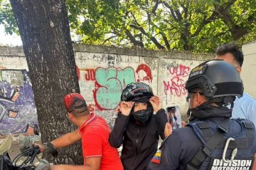 A opositora María Corina é filmada por um agente da Polícia Nacional pouco antes de sair de um protesto