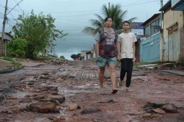 Rosalina Silva, 50, e o filho Ruan, 11, moram no Pôr do Sol. Ela conta que a chuva arrancou a pista nova que havia sido construída  -  (crédito: Ed Alves/CB/D.A Press)