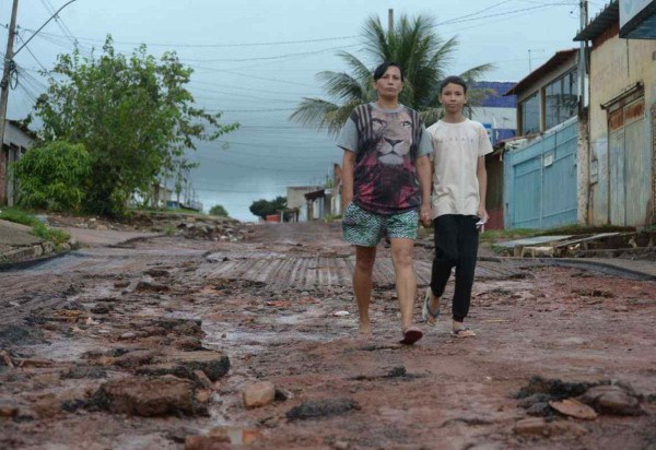 Rosalina Silva, 50, e o filho Ruan, 11, moram no Pôr do Sol. Ela conta que a chuva arrancou a pista nova que havia sido construída  -  (crédito: Ed Alves/CB/D.A Press)