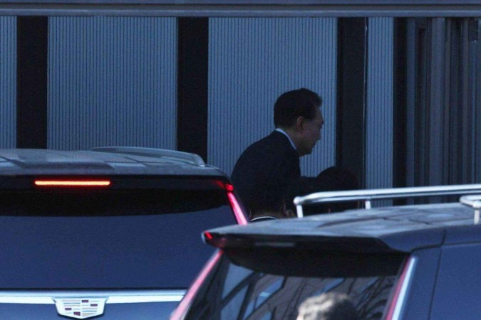 Policiais e autoridades deixam a região da residência oficial do presidente sul-coreano Yoon Suk Yeol após sua prisão, em Seul -  (crédito: REUTERS/Kim Hong-Ji)