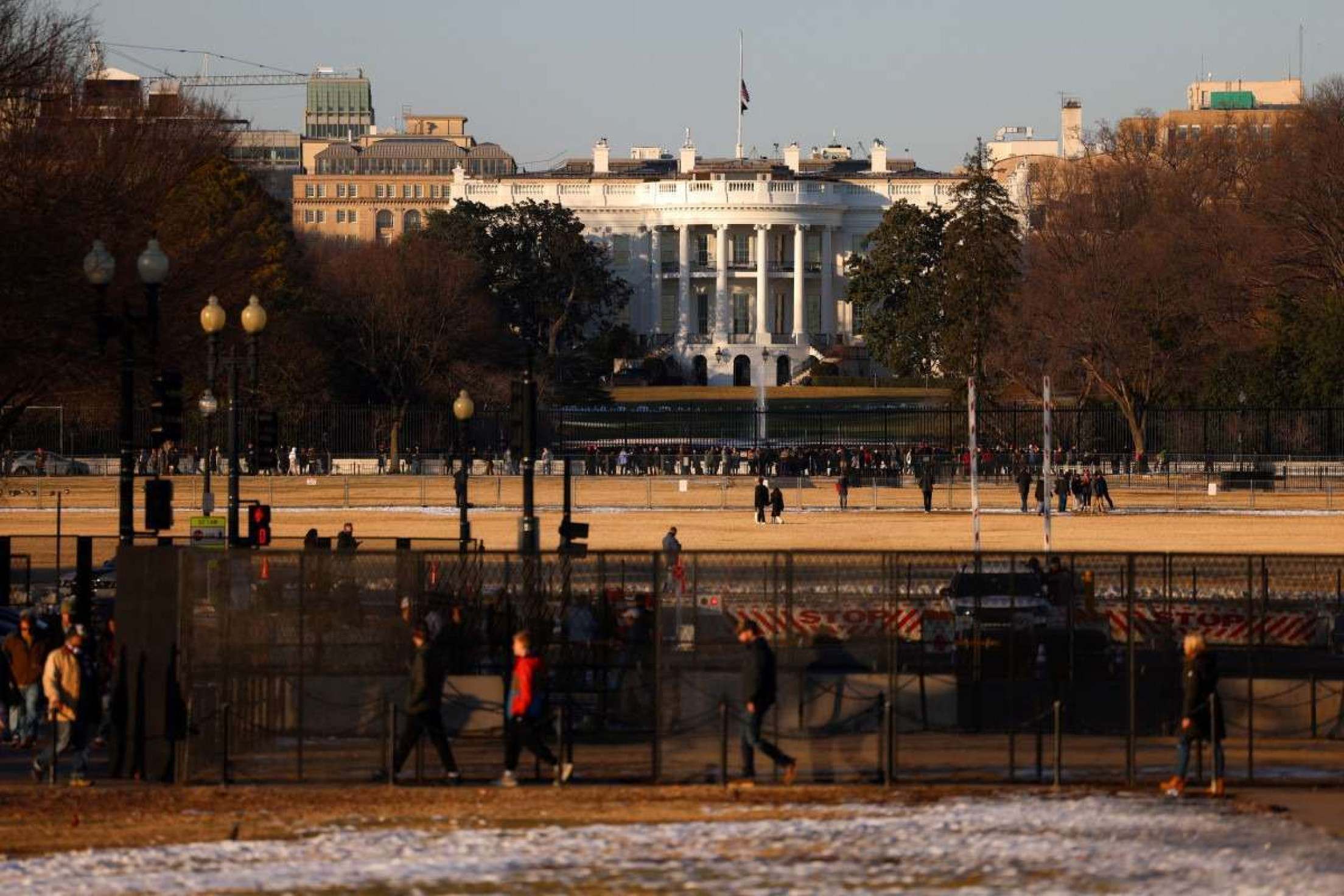 Pessoas passam pela Casa Branca em Washington, DC, em 18 de janeiro de 2025, enquanto a capital dos EUA se prepara para a posse do presidente eleito dos EUA, Donald Trump. Donald Trump confirmou que sua posse como presidente dos EUA em 20 de janeiro será em um local fechado devido ao clima congelante esperado, minando as esperanças do republicano de um espetáculo grandioso para dar início ao seu segundo mandato. (Foto de CHARLY TRIBALLEAU / AFP)      