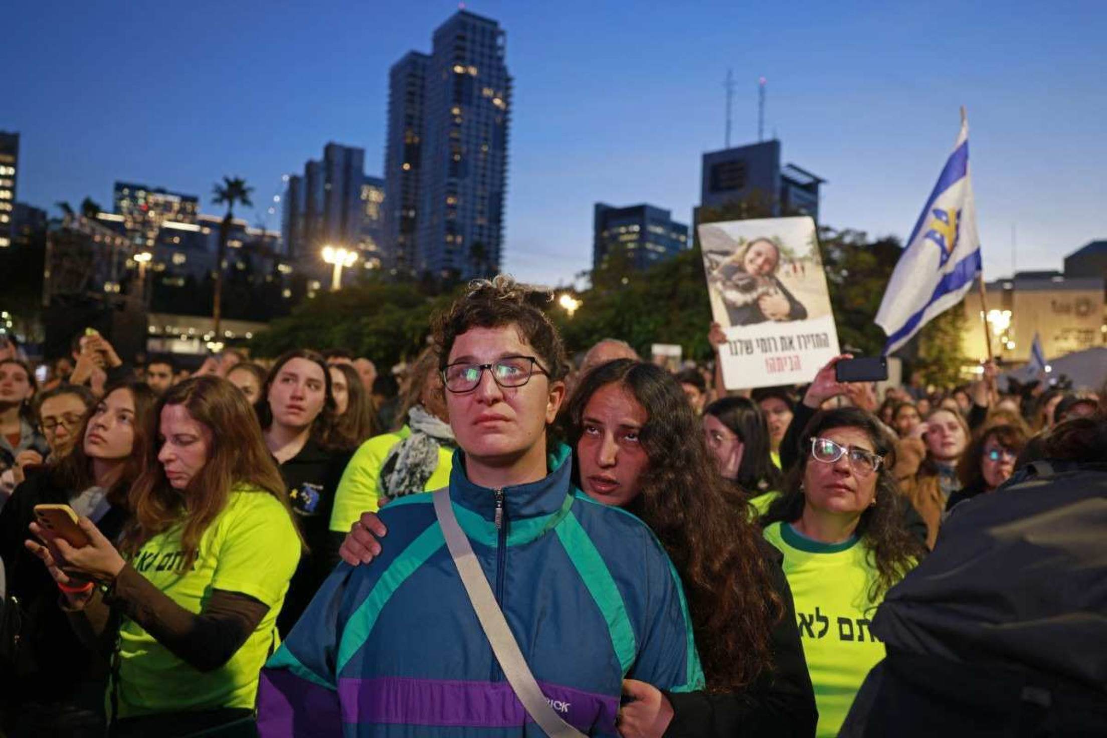 Apoiadores e familiares reagem enquanto assistem a uma transmissão de televisão ao vivo sobre a libertação de reféns israelenses      