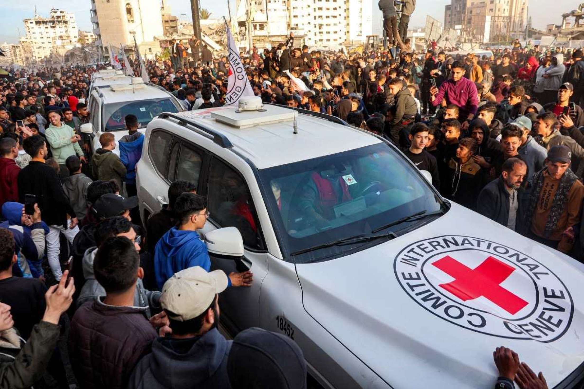 Pessoas se reúnem em torno de um veículo do Comitê Internacional da Cruz Vermelha (CICV) na Praça Saraya, no oeste da Cidade de Gaza, em 19 de janeiro de 2025      