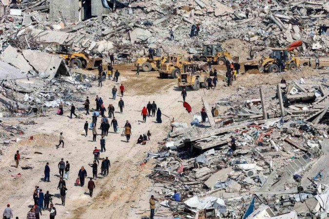 Palestinos circulam entre os escombros de edifícios destruídos no campo de refugiados palestinos de Jabalia, no norte da Faixa de Gaza - (crédito: AFP) Palestinos circulam entre os escombros de edifícios destruídos no campo de refugiados palestinos de Jabalia, no norte da Faixa de Gaza - (crédito: AFP)