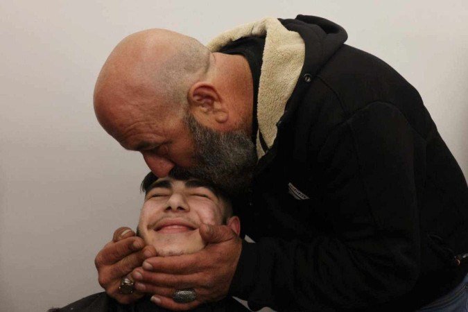 Jovem palestino de 17 anos recebe o carinho da família após ser detido em uma prisão de Israel - (crédito: AHMAD GHARABLI/AFP) Jovem palestino de 17 anos recebe o carinho da família após ser detido em uma prisão de Israel - (crédito: AHMAD GHARABLI/AFP)