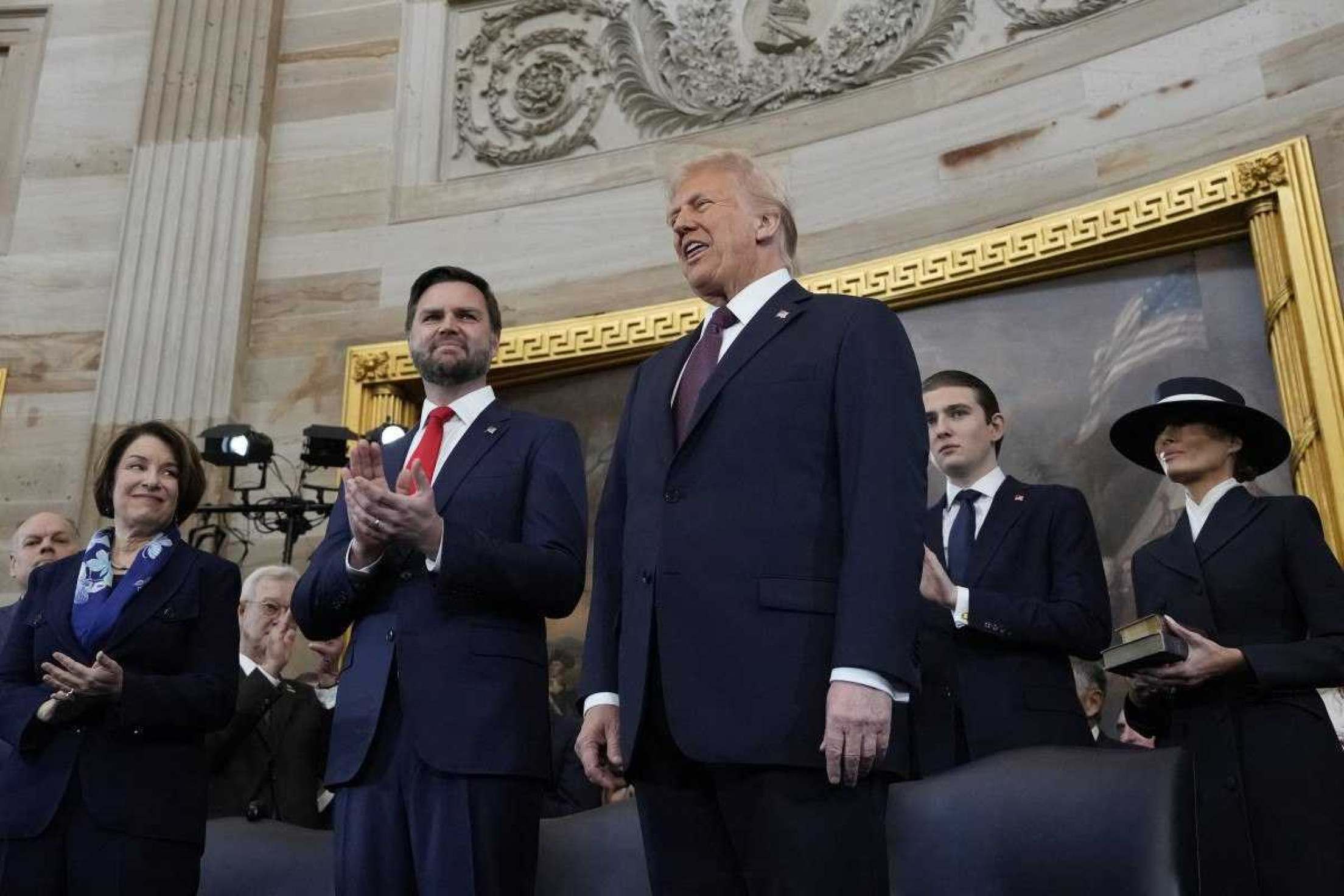         O vice-presidente eleito dos EUA, JD Vance, e o presidente eleito dos EUA, Donald Trump, são vistos no palco antes de prestar juramento de posse