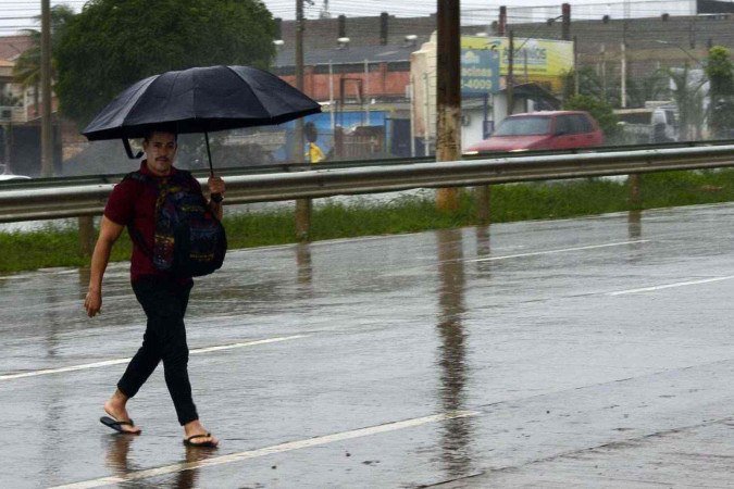 Na via Estrutural, em frente à Vicente Pires, Cleiton Jesus, de 34 anos, precisou atravessar a pista sob forte chuva, protegido apenas por um guarda-chuva